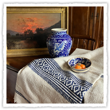 A talavera jar, sunset painting and traditional Mexican blanket